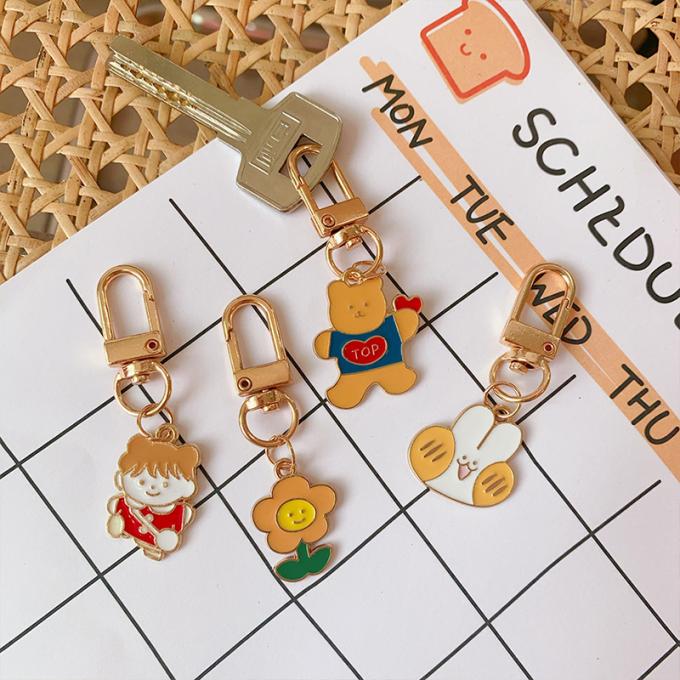Le sac pendant de lapin de chaîne principale petit en métal en gros de fleur ornemente la bande dessinée mignonne Keychains d'accessoires pour des femmes